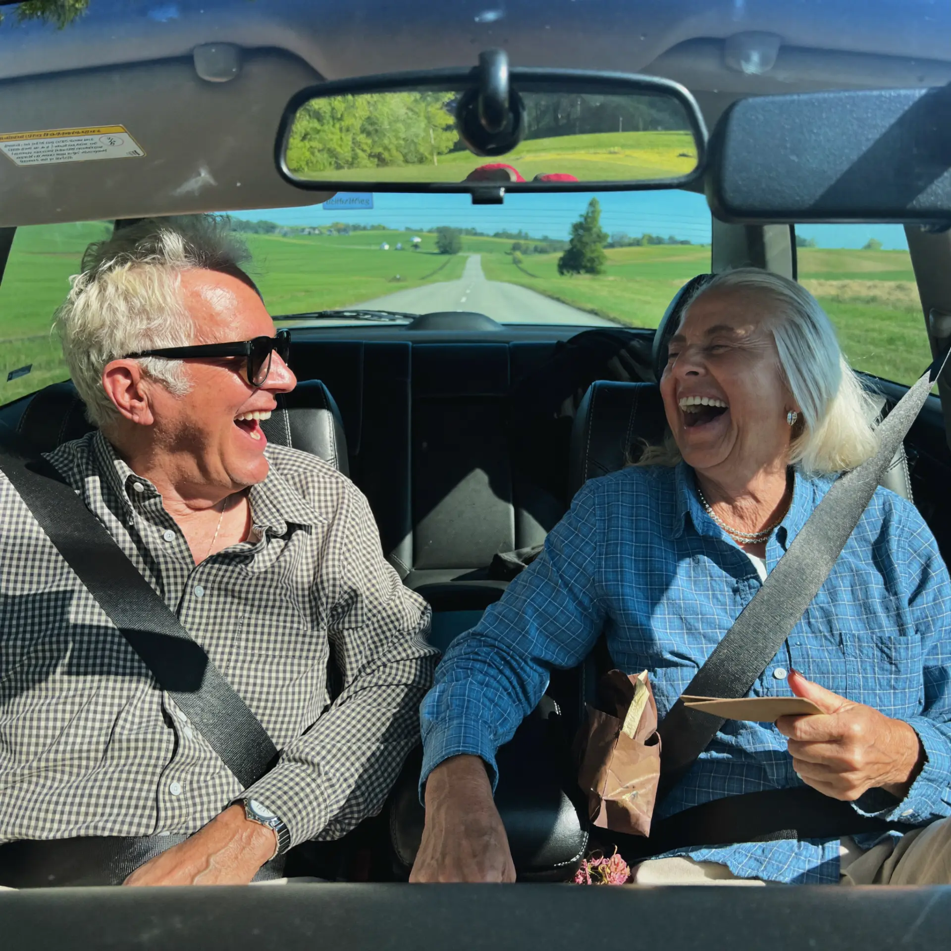 Retired couple laughing on a drive
